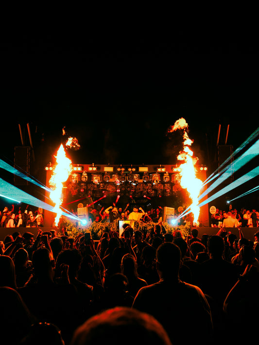 Concert stage with towering flames shooting into the air as thousands of fans cheer beneath dramatic lighting, capturing the explosive energy and global impact of Jamaica’s golden era of reggae and dancehall music.