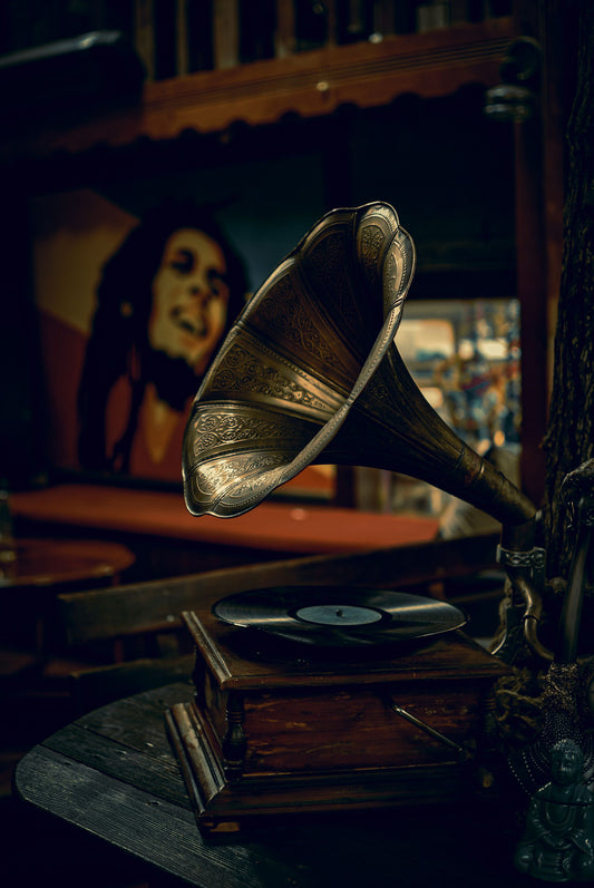 Vintage gramophone playing music with a Bob Marley poster in the background, symbolizing Jamaica’s reggae legacy, global influence, and the evolution of Caribbean music from roots to international success.